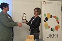 UKKT:n sihteeri Arja Lusa ojentaa palkinnon Minna Rikkiselle